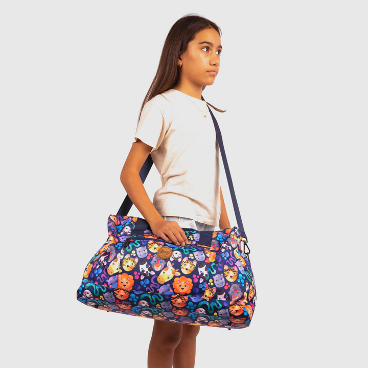 young girl wearing alimasy navy kids safari duffle bag across body 