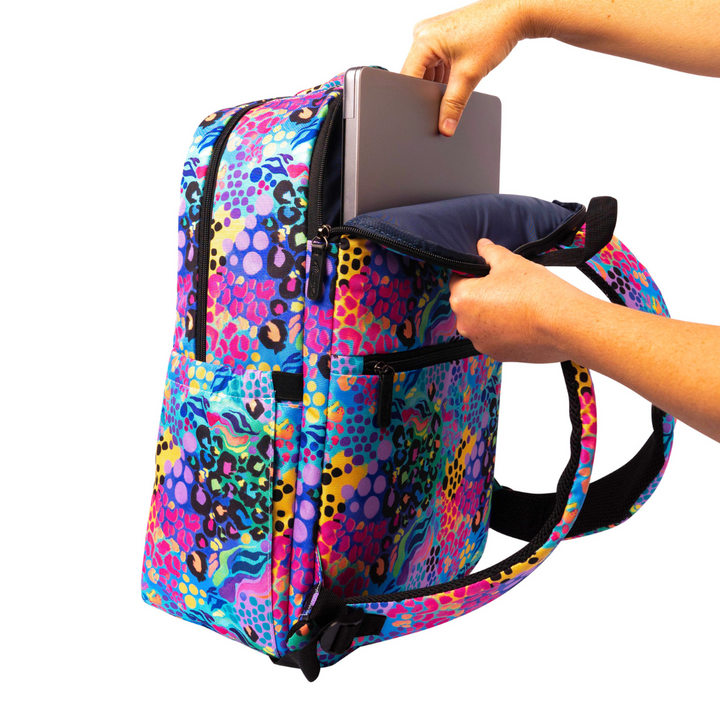 hand placing laptop into back pocket of ladies alimasy electric leopard laptop backpack