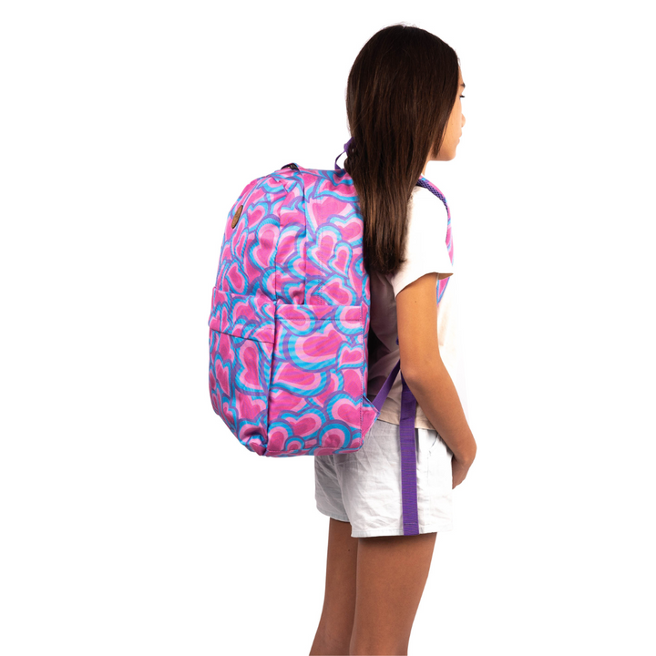 girl wearing alimasy pink heart kids school backpack on back side view
