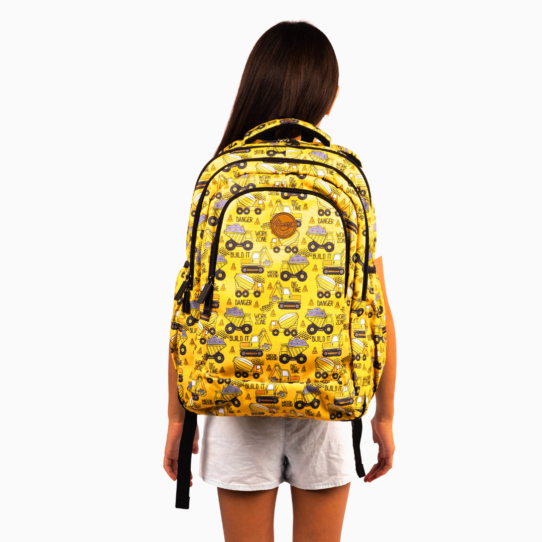 girl wearing yellow alimasy construction pattern large backpack on back 